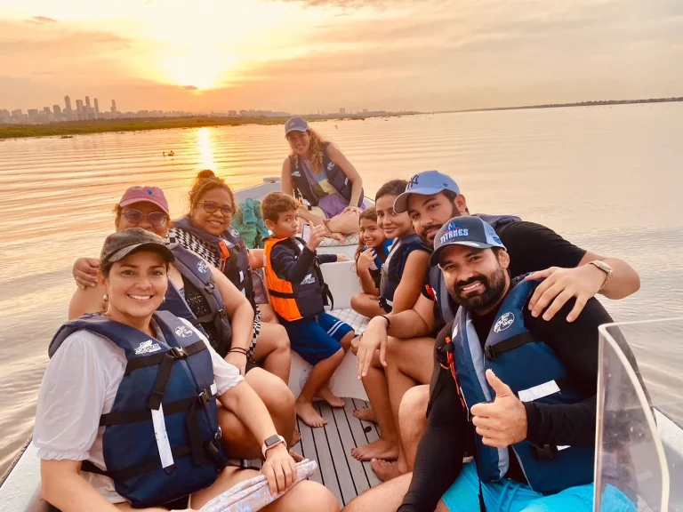 Grupo de turistas en lancha por el Río Magdalena en Barranquilla, disfrutando del paisaje y la naturaleza.